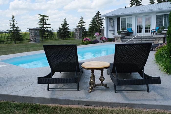 The cottage pool house with the wrought iron fence in the background.